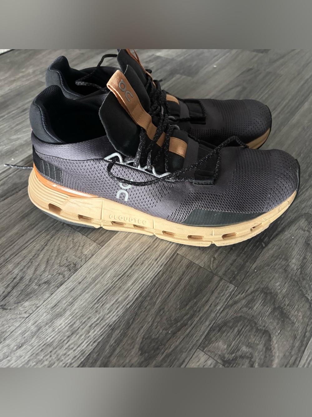 On Running women’s Black and burnt orange tennis shoes